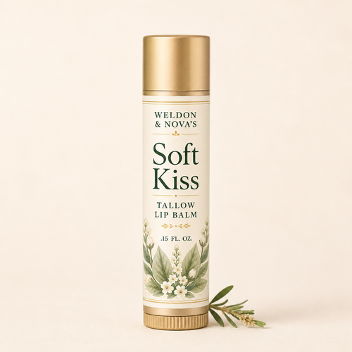 Weldon & Nova's Soft Kiss Tallow Lip Balm in a cylindrical white and gold tube with botanical illustrations, set against a solid cream background with a sprig of green leaves at its base.